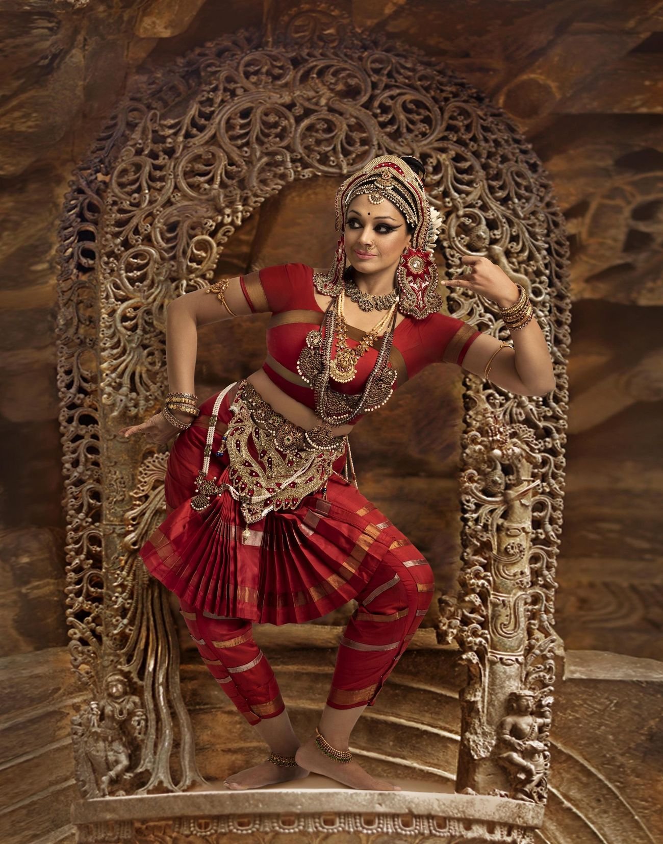 Padma Bhushan Shobana in Bharatanatyam costume, framed by a carved temple arch